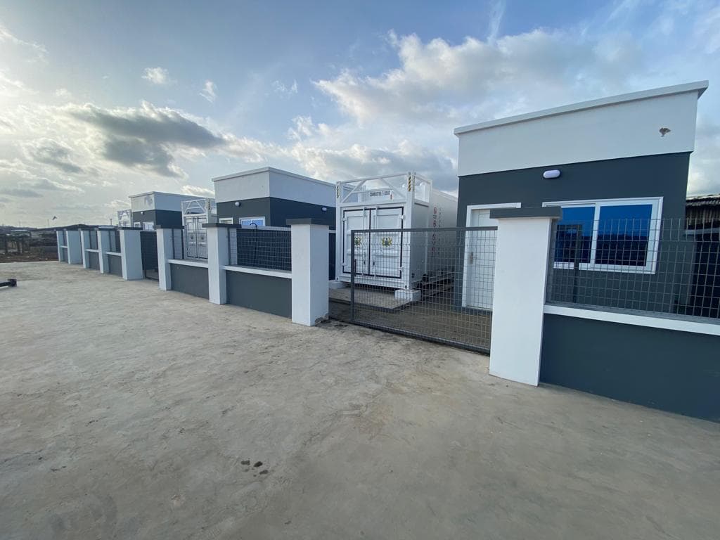 Several dark grey automated premix fuel station units in a paved compound